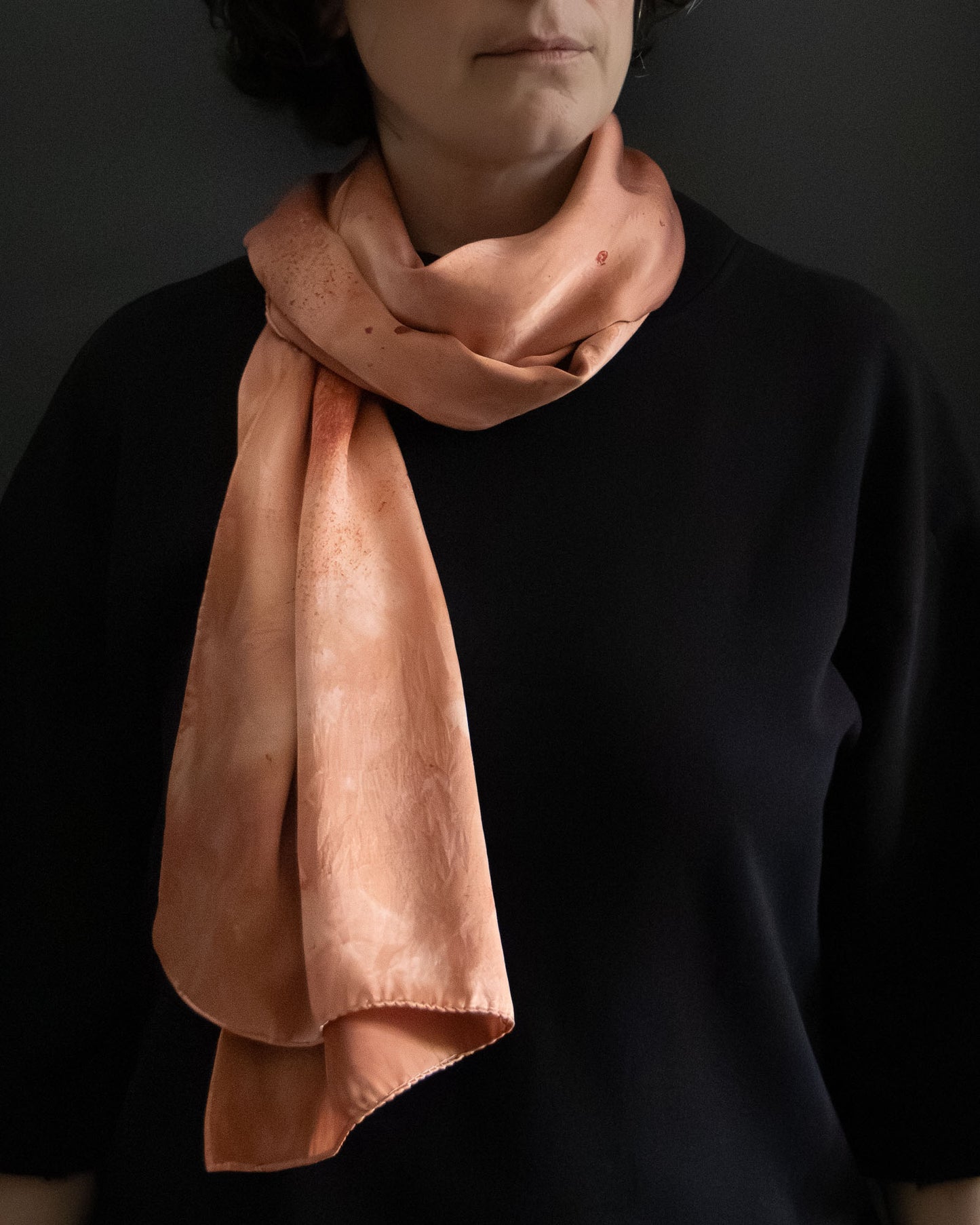 long silk scarf worn loosely, rich earthy red tones