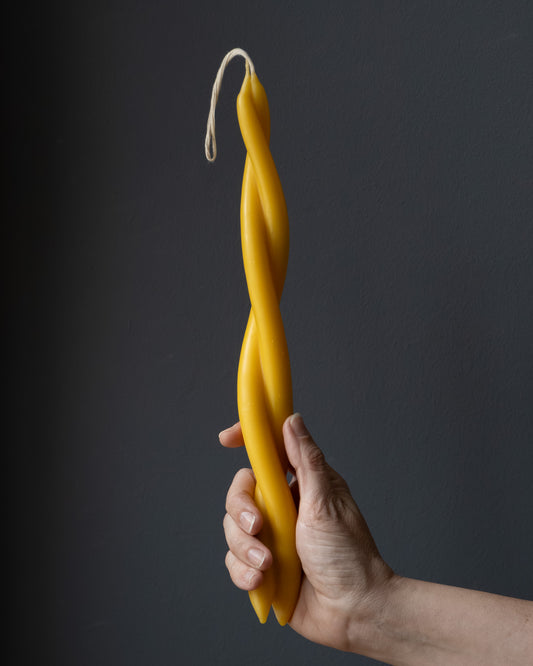 Hand holding a twisted beeswax candle