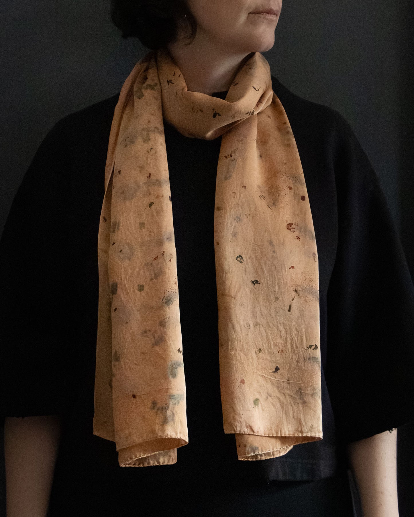 long silk scarf worn loosely, warm earthy orange tones
