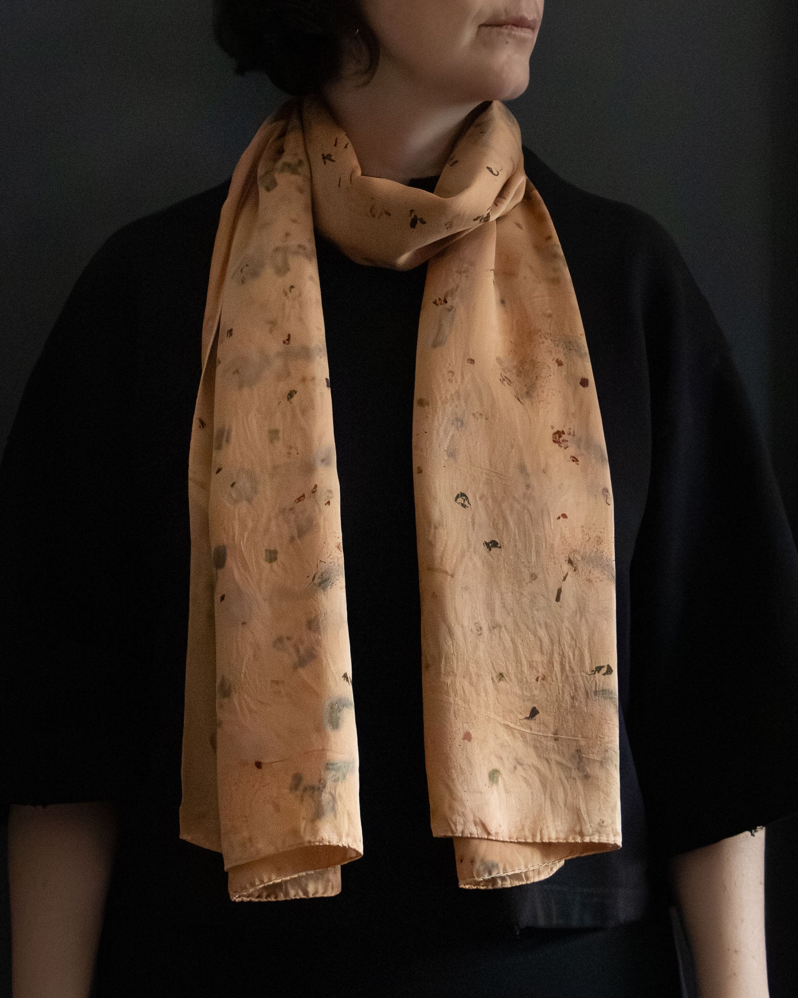long silk scarf worn loosely, warm earthy orange tones