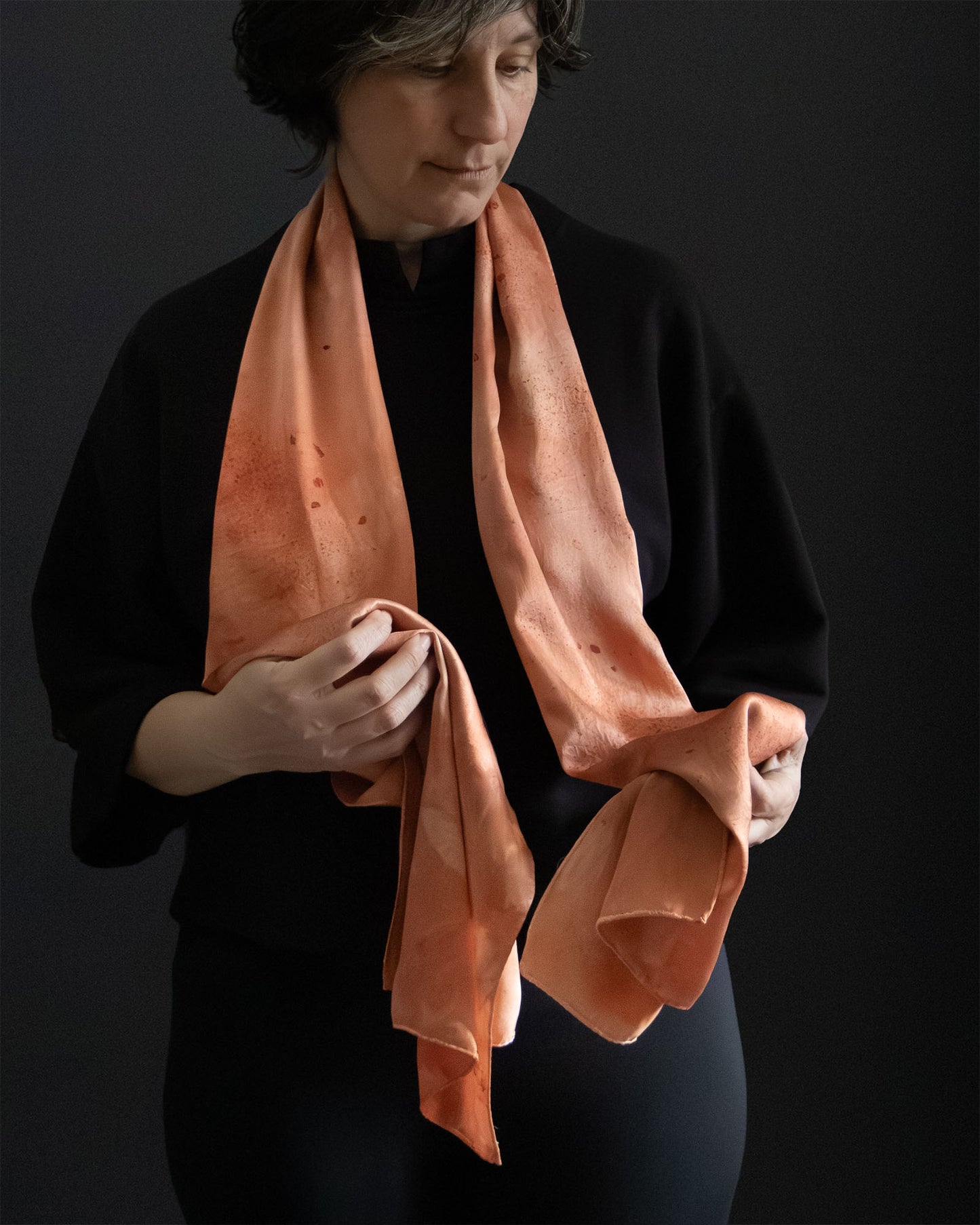 silk scarf in warm red-orange tones, naturally dyed, worn front view