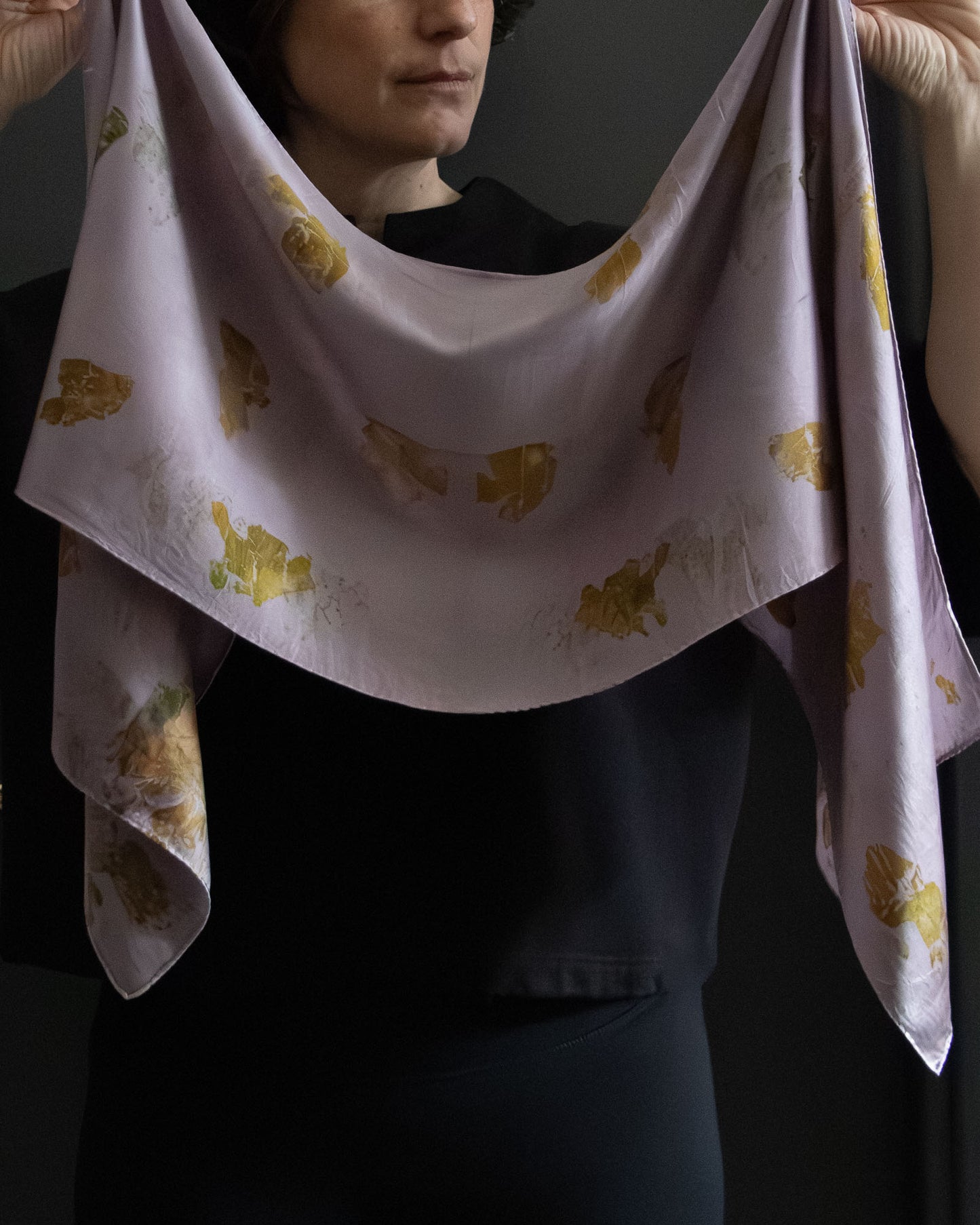 naturally dyed silk scarf with botanical prints, held open
