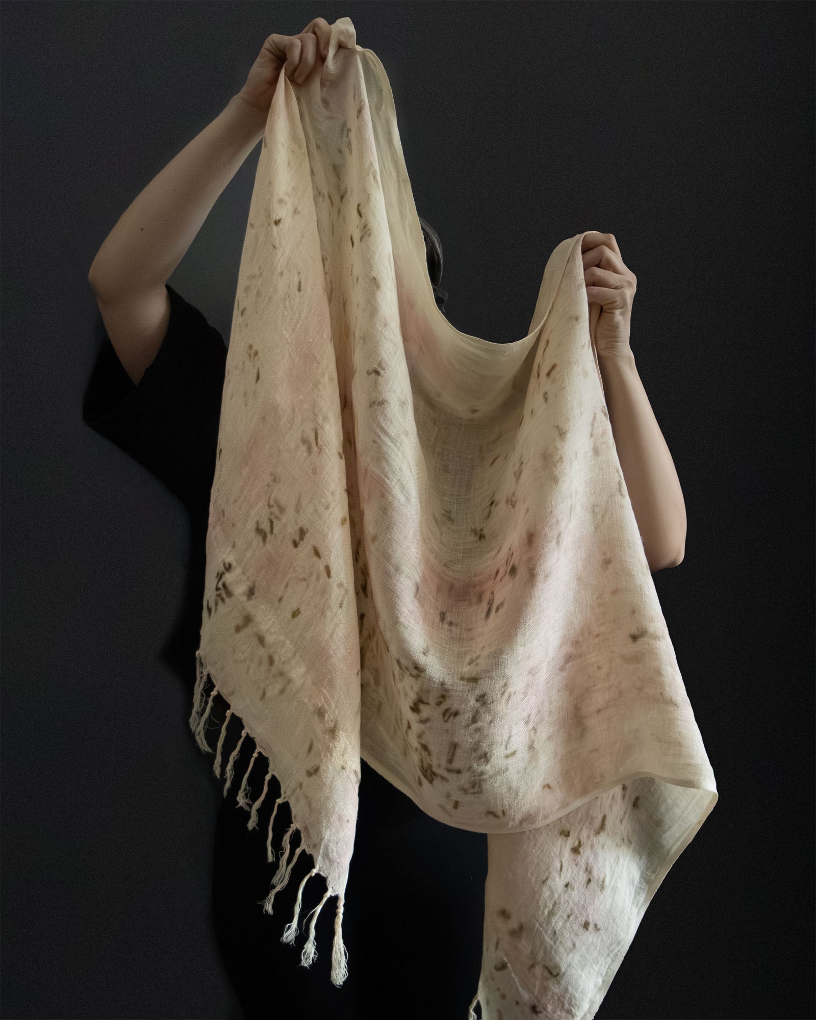 hands holding a naturally dyed linen scarf, one of a kind