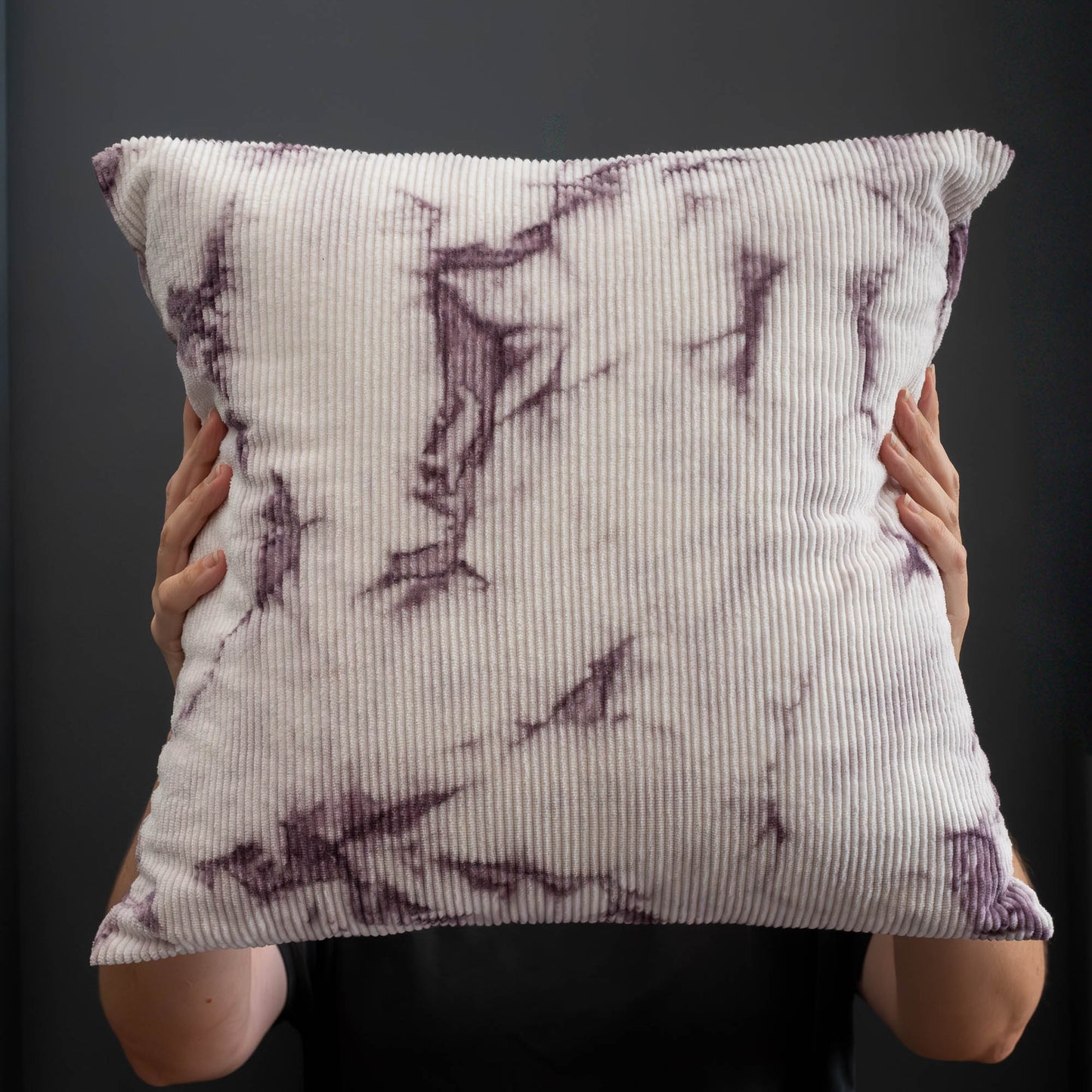 Handcrafted corduroy cushion cover naturally dyed with logwood, shown held upright.