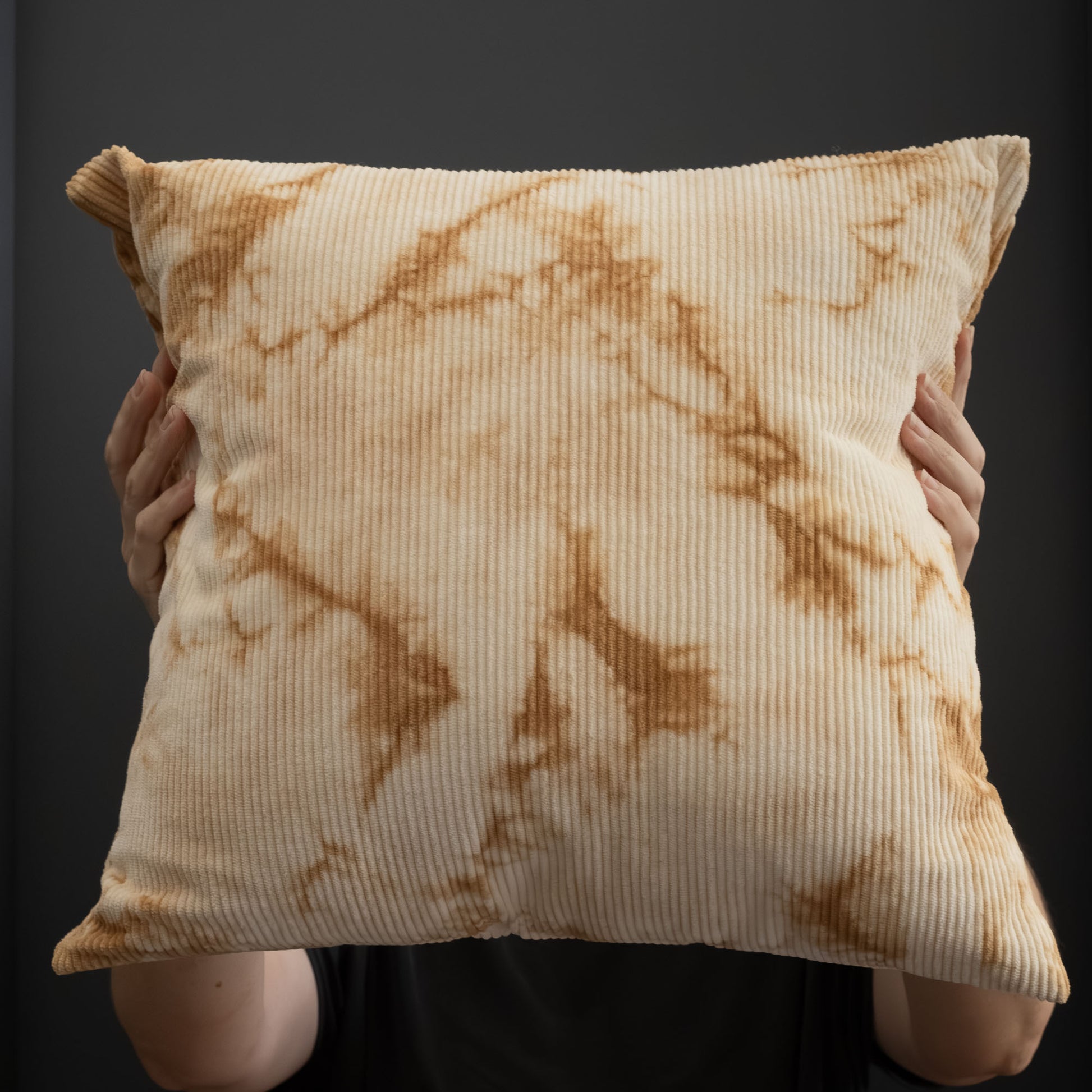 Handcrafted corduroy cushion cover naturally dyed with oak bark, shown held upright.