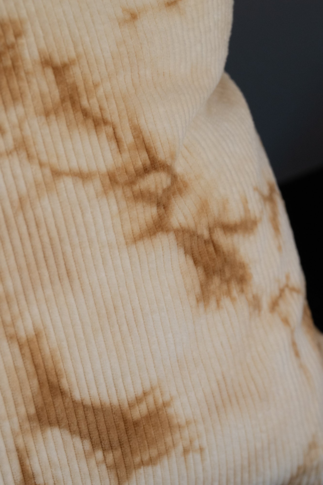 Close-up of natural oak-bark dye brown patterns on organic cotton corduroy cushion cover.