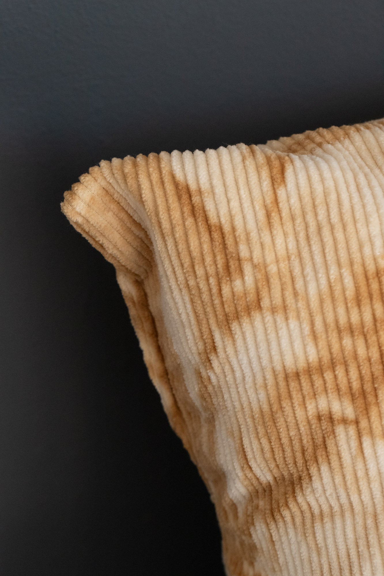 Detail of naturally dyed corduroy cushion cover with oak-bark tie-dye patterns.
