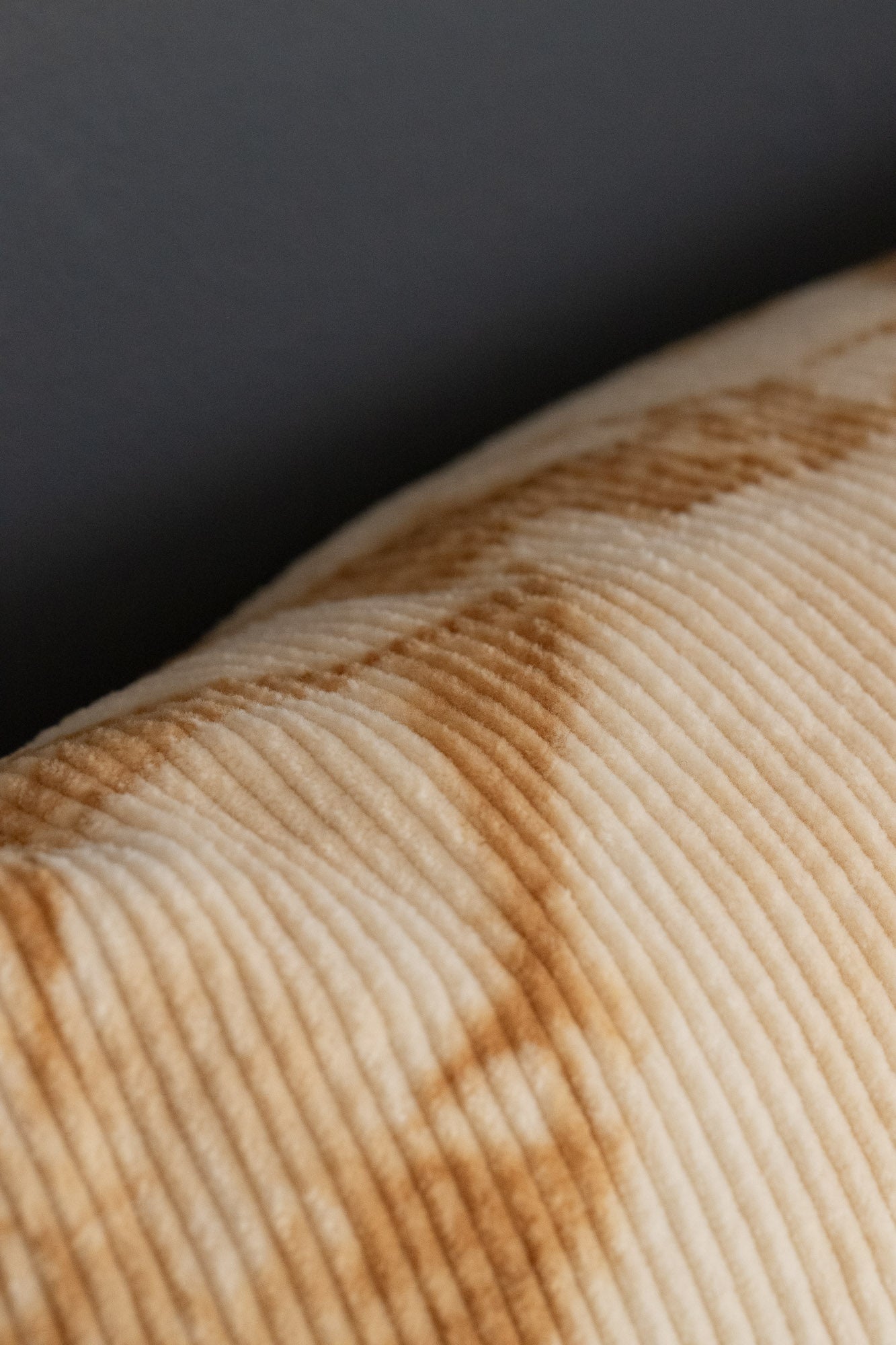 Side view of organic cotton corduroy cushion cover showing warm brown oak-bark dye markings.