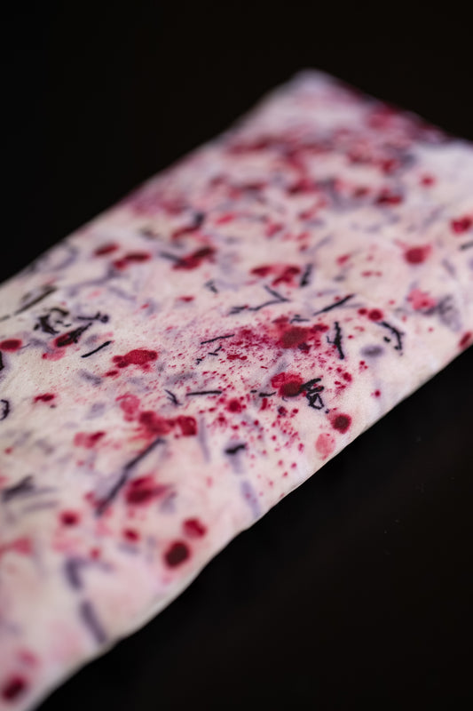 Close-up of naturally dyed silk eye pillow showing red and purple eco-print patterns on Greek mulberry silk.