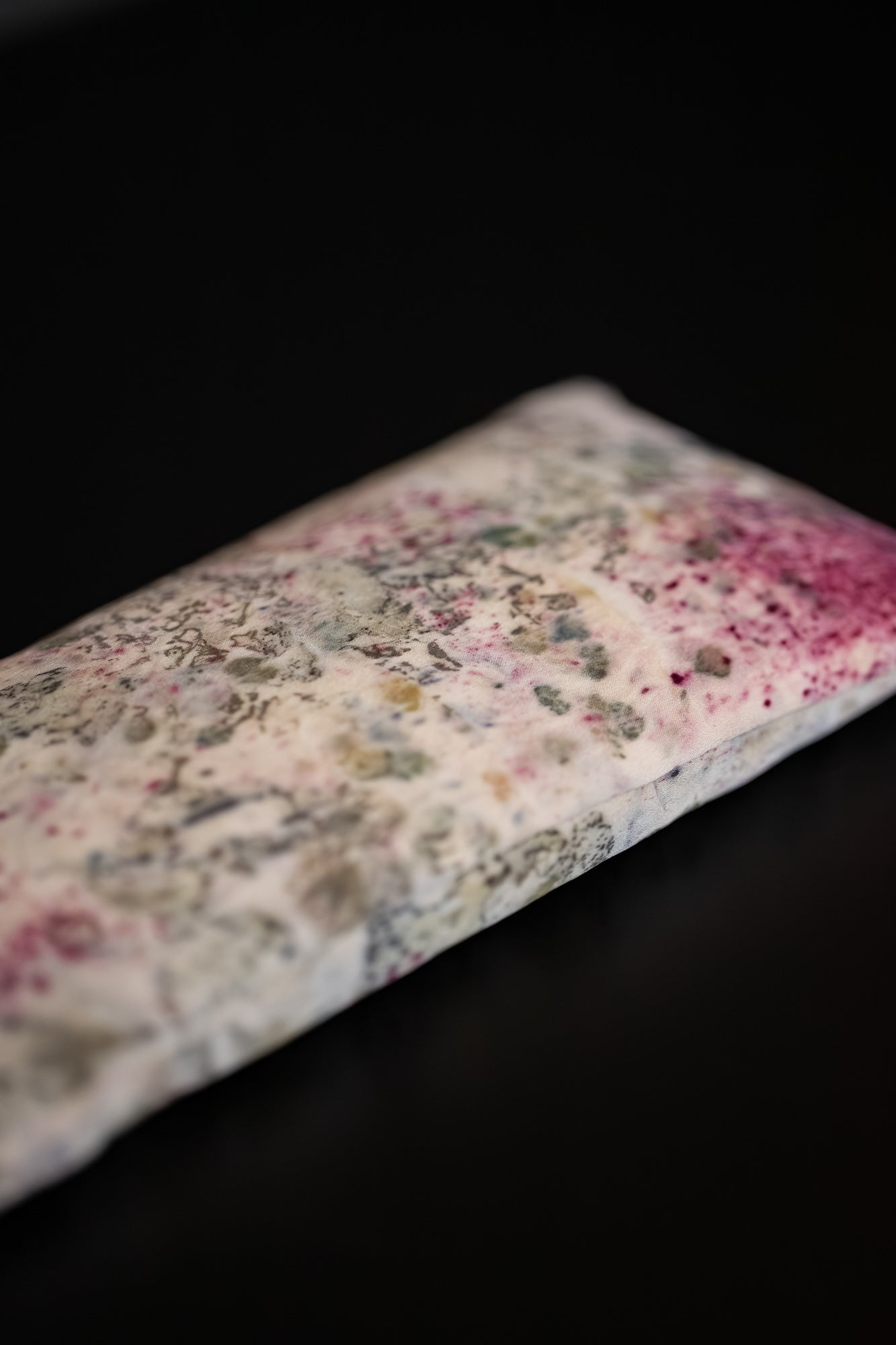 Detail of a one-of-a-kind silk eye pillow showing subtle natural dye patterns.
